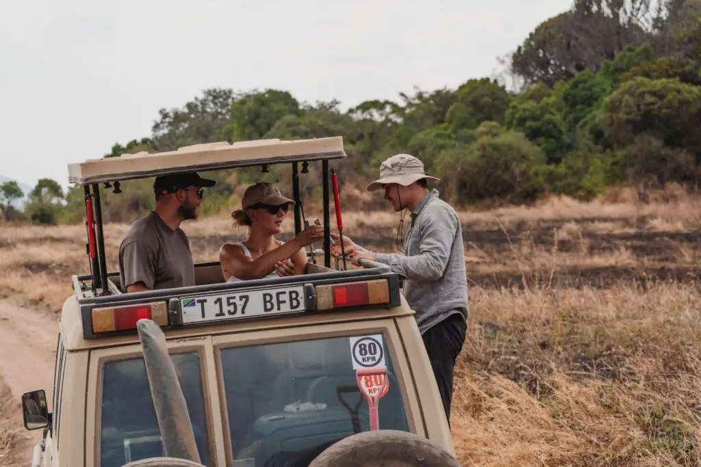 people on safari in Tanzania getting water from a guide